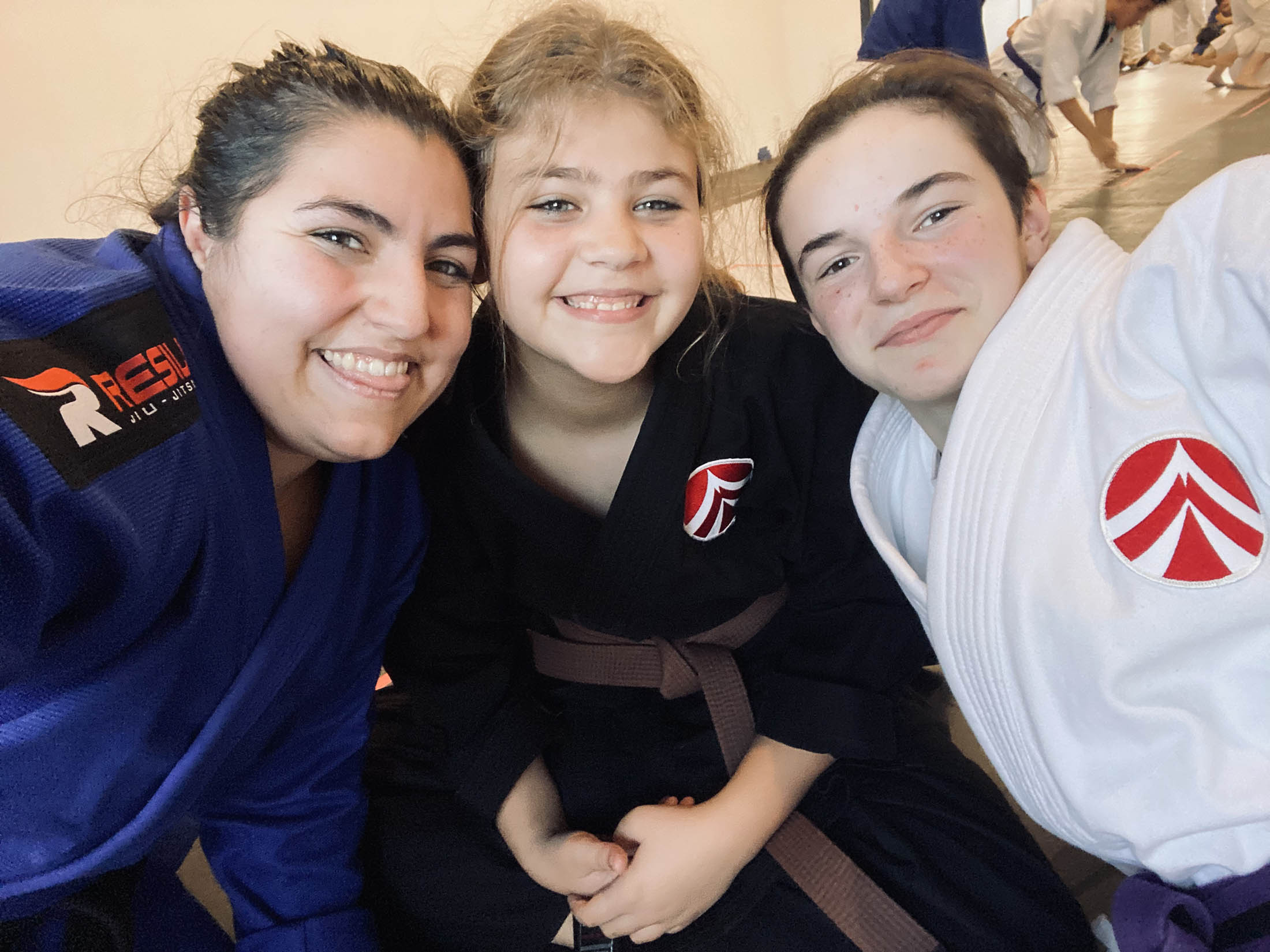 content-2 Group of instructors and students smiling for a photo on the mats.