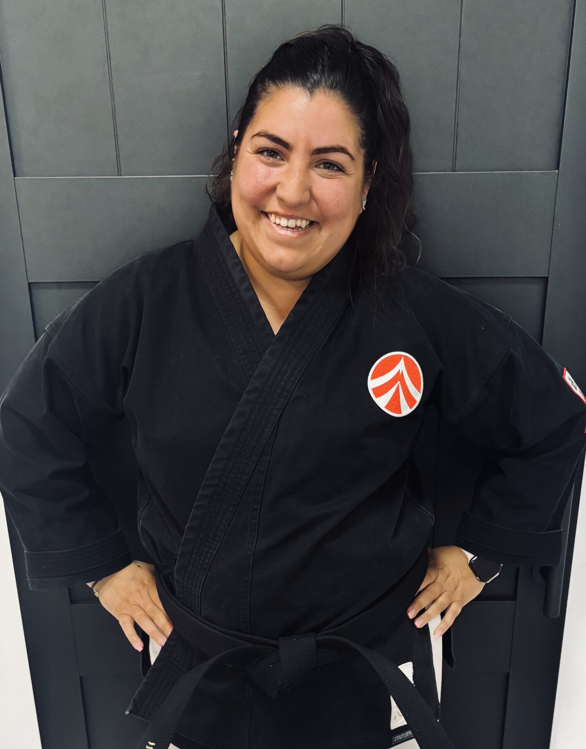 IMG_8001 Karate instructor wearing a black gi posing and smiling for a portrait.