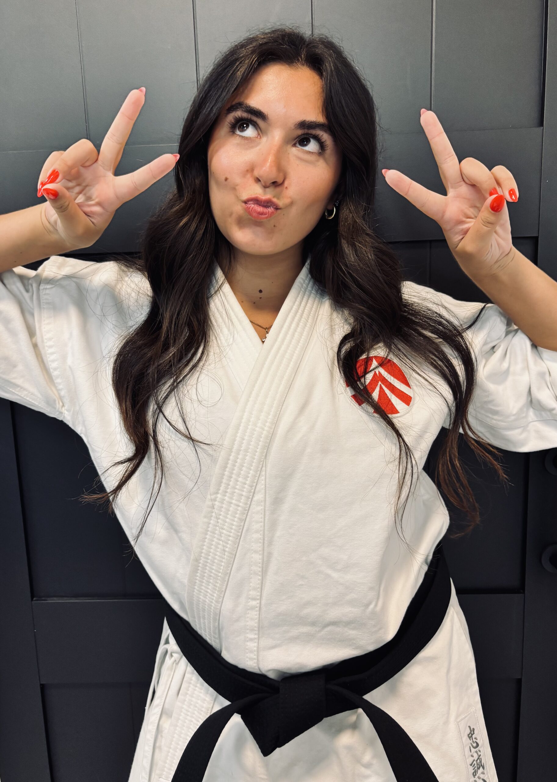 IMG_9736 Karate student in a white gi making a peace sign pose for a fun photo.