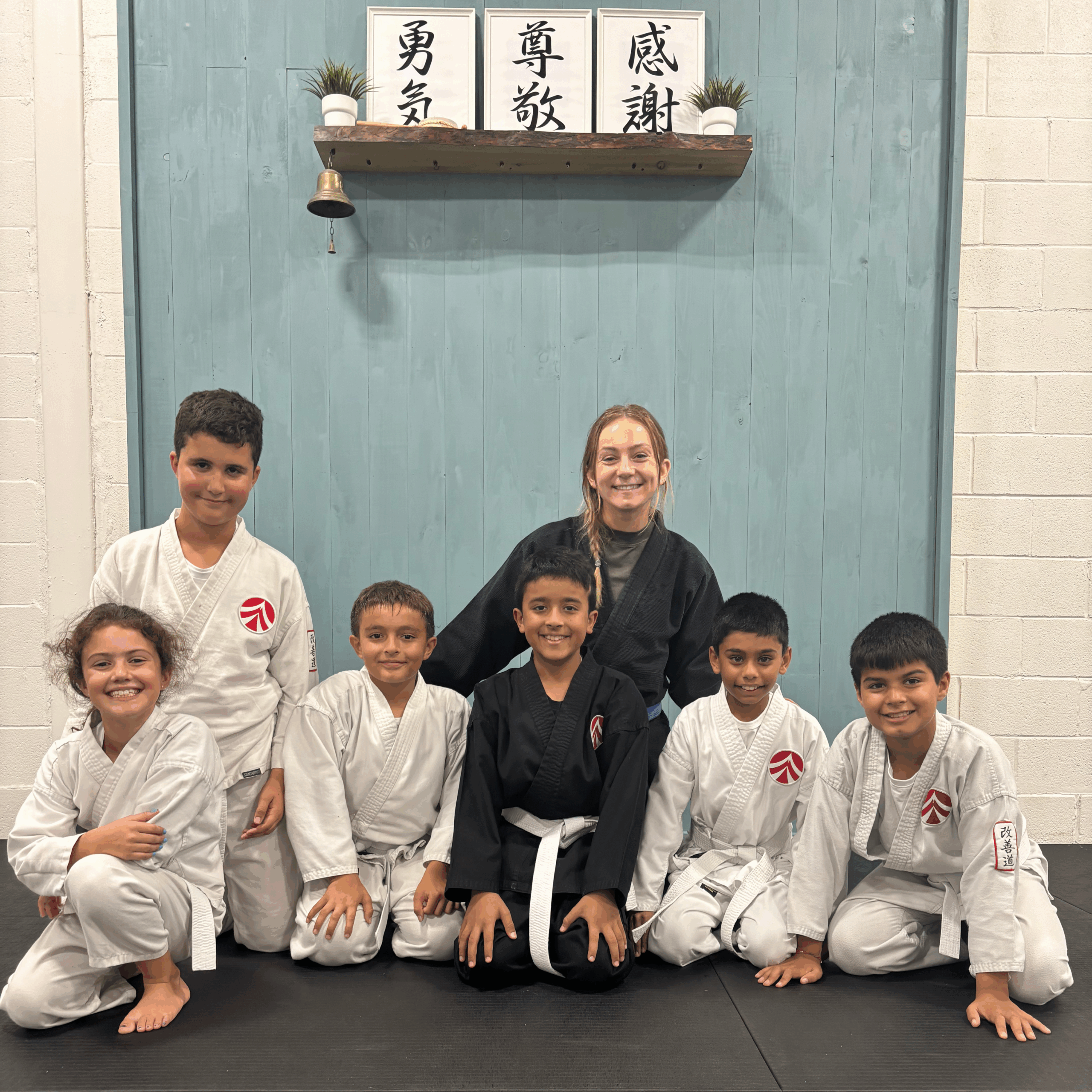 7 Karate students posing with instructors after class at AMA Dojo.